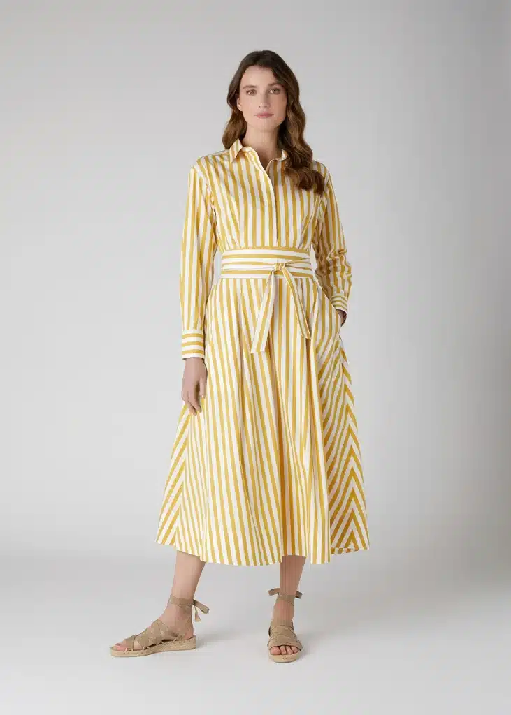 A woman wearing a yellow and white striped dress.