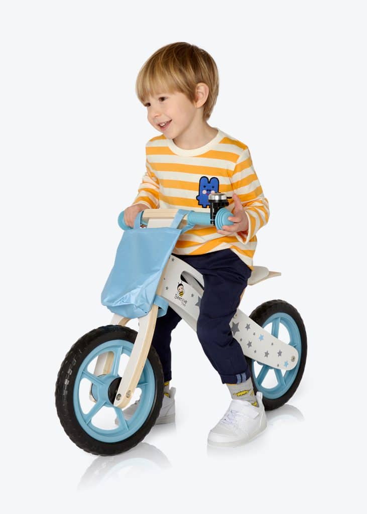 A young boy on a blue and yellow balance bike.